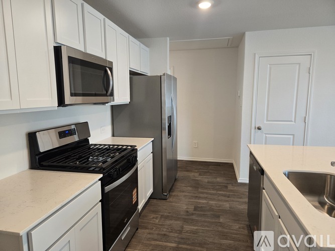 A kitchen with white cabinets and a black stove top oven.