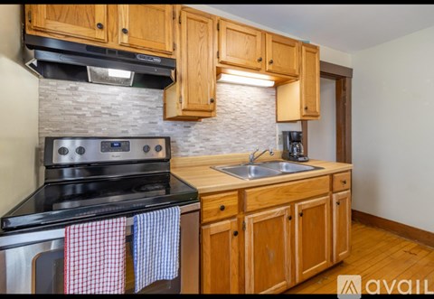 A kitchen with wooden cabinets and a black stove top oven.