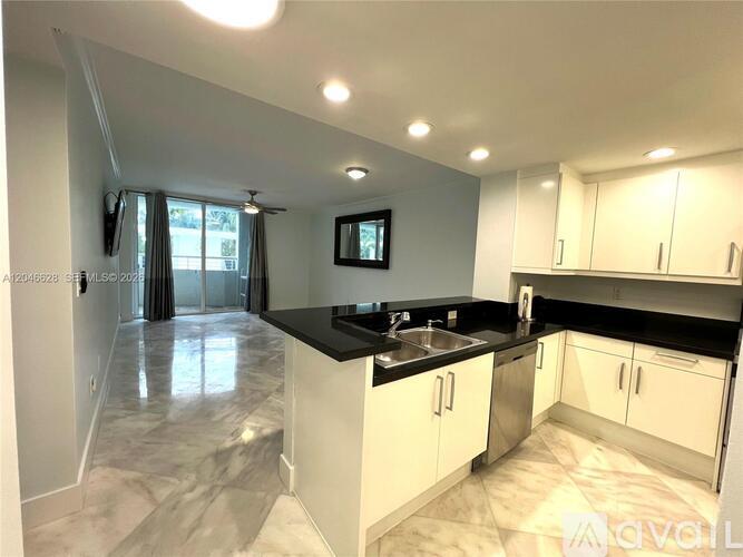 A modern kitchen with white cabinets and a black countertop.
