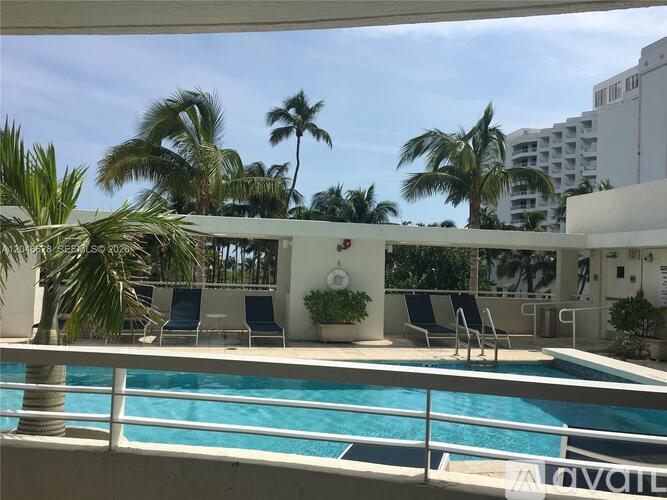 A pool with chairs and palm trees in the background.