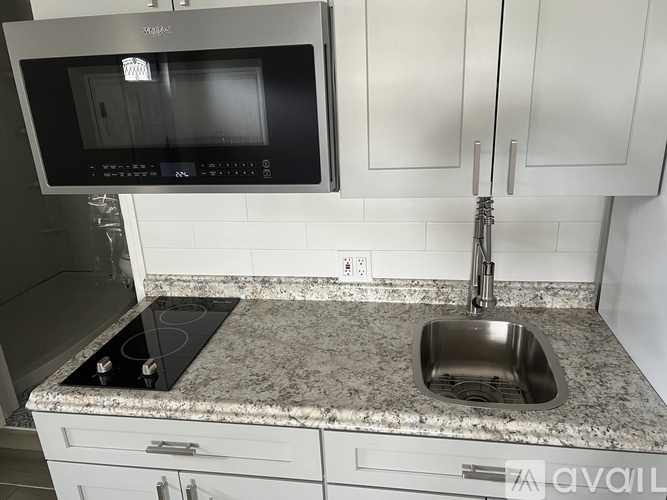 A kitchen with a granite countertop and a stove top oven.