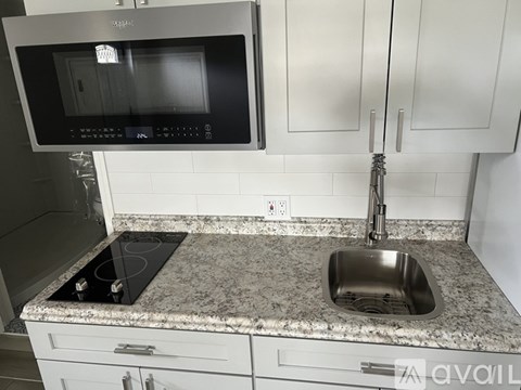 A kitchen with a granite countertop and a stove top oven.