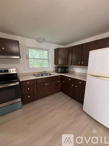 A kitchen with brown cabinets and a white fridge.