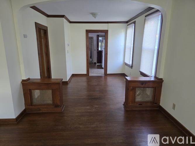 A room with wood floors and two wood-burning stoves.