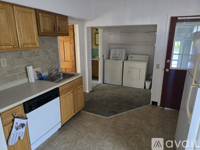 A kitchen with wooden cabinets and a white dishwasher.