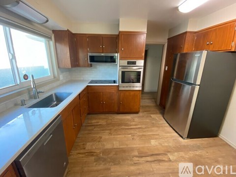 A kitchen with wooden cabinets and a refrigerator.