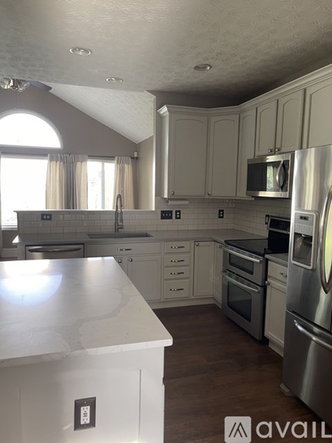 A kitchen with white cabinets and a white counter top.