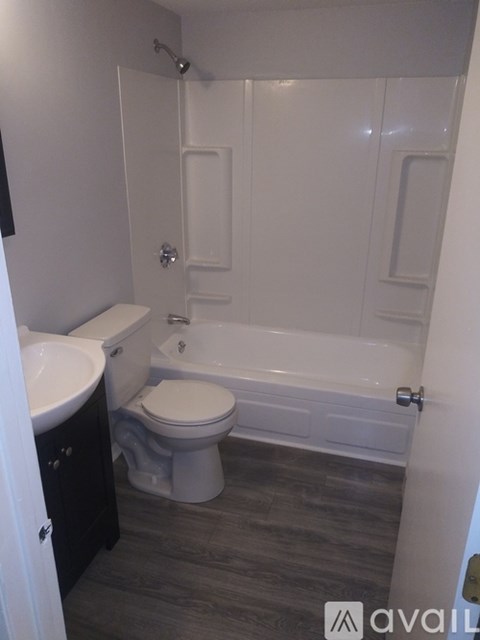 A bathroom with a toilet, sink, and bathtub.