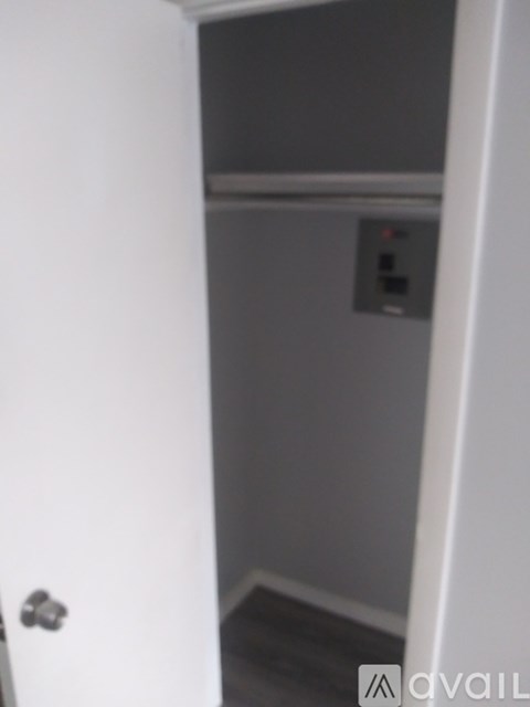 A white door with a silver handle is open.