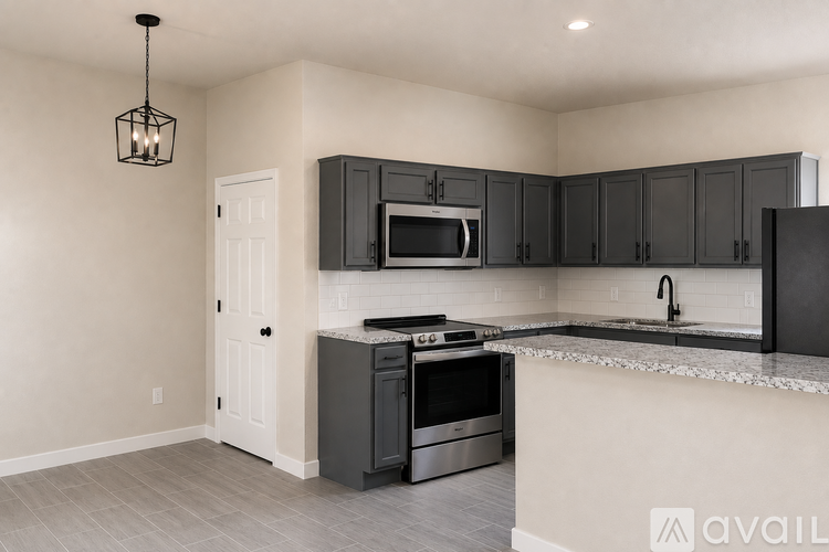 A kitchen with black cabinets and a white door.