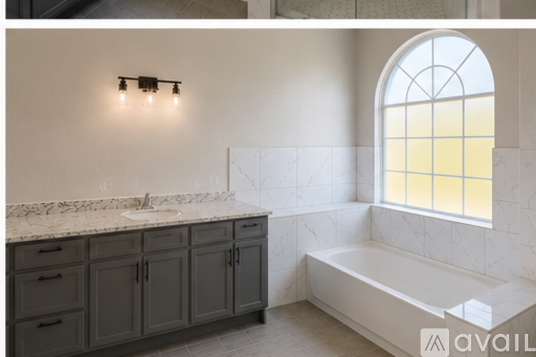 A bathroom with a marble countertop and a large window.
