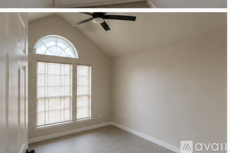 A room with a ceiling fan and a window with blinds.