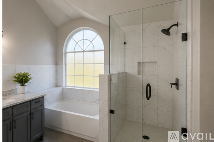 A bathroom with a tub, shower, and a window.