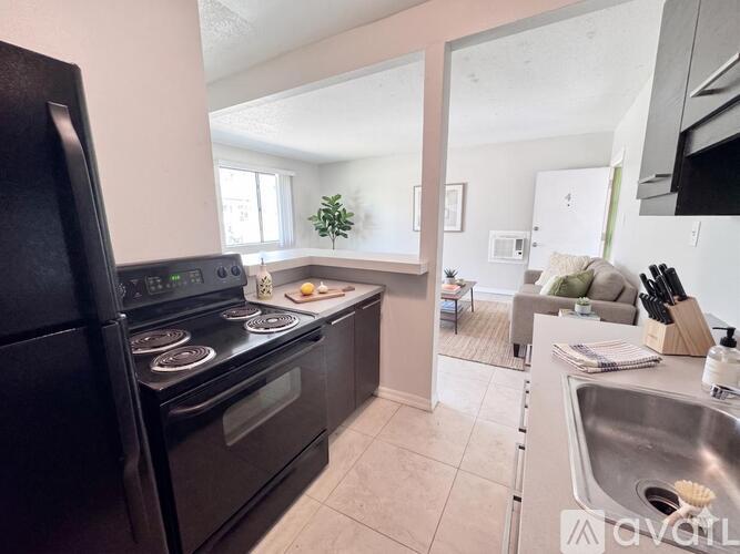A kitchen with black appliances and a stove top oven.