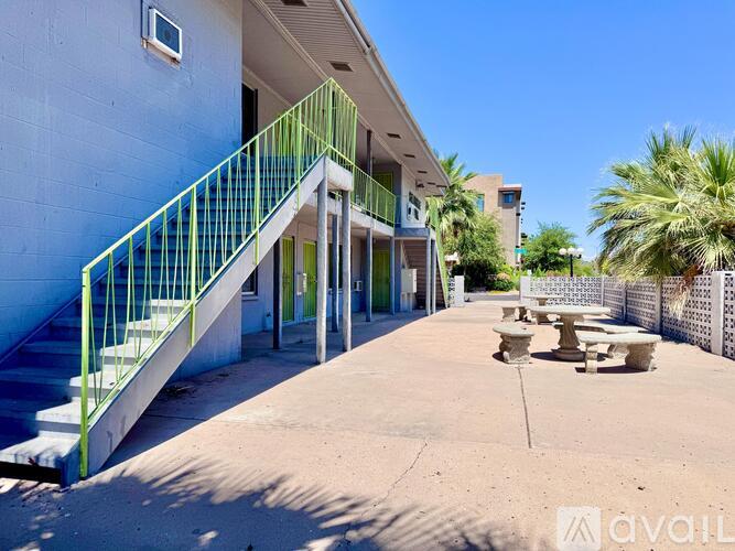 A building with a blue wall and a green railing.