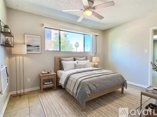 A bedroom with a large bed and a ceiling fan.