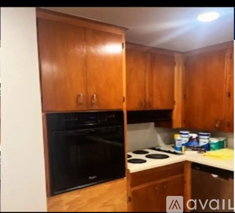 A kitchen with wooden cabinets and a black oven.