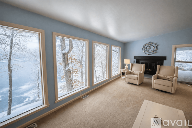 A living room with a fireplace and a view of a snowy landscape.