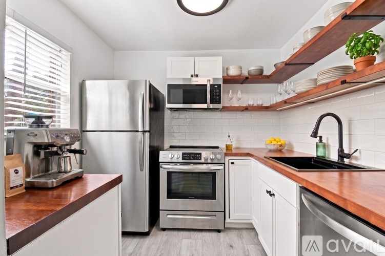 A kitchen with a refrigerator, oven, and sink.