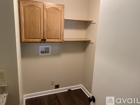 A kitchen with wooden cabinets and a white wall.