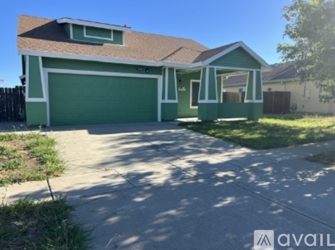 A house with a green garage door is for sale.