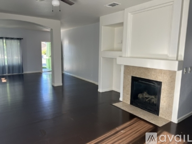 A living room with a fireplace and wooden floors.