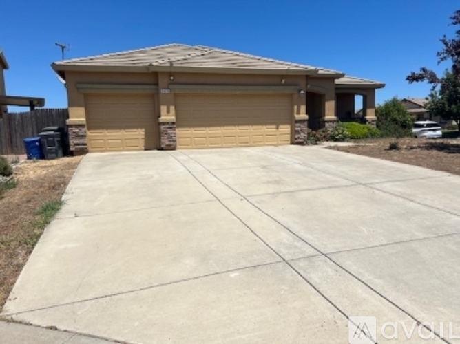 A house with a tan garage door and a brown roof.