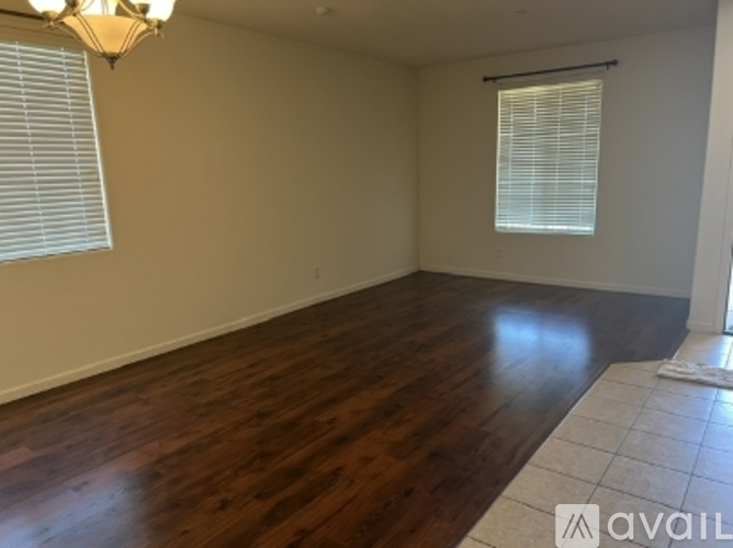 A room with wooden flooring and a chandelier.