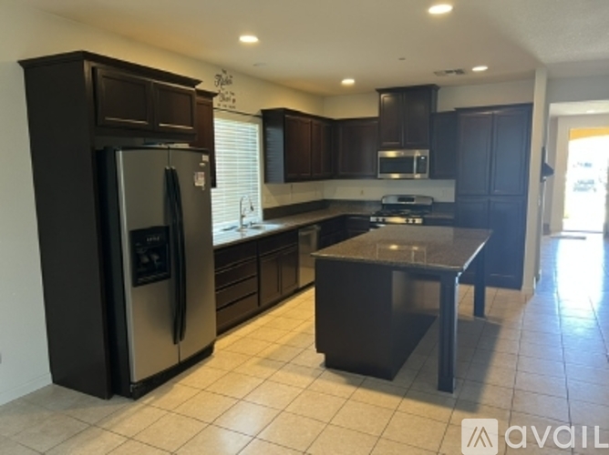 A kitchen with a black fridge and a black island.