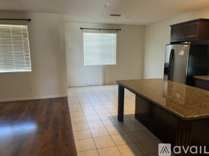 A kitchen with a granite countertop and a refrigerator.