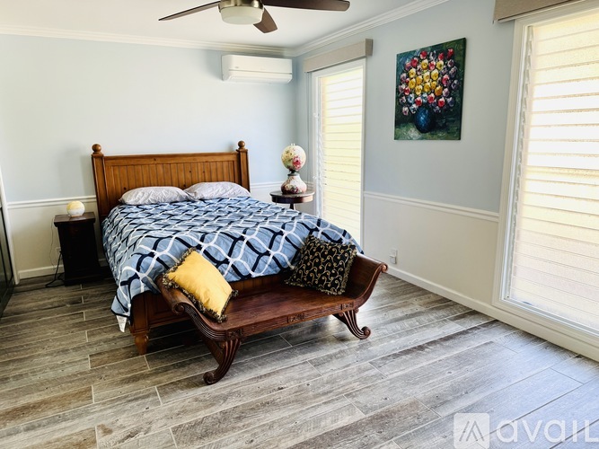 A bedroom with a bed and a painting on the wall.