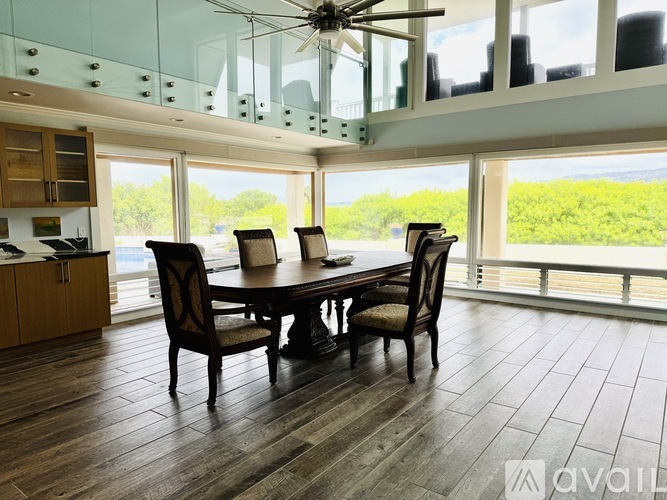 A dining room with a table and chairs and a ceiling fan.