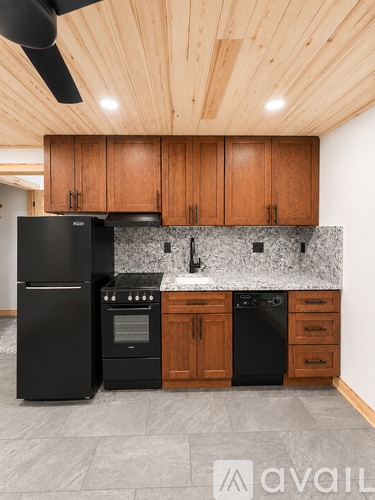 A kitchen with black appliances and wooden cabinets.