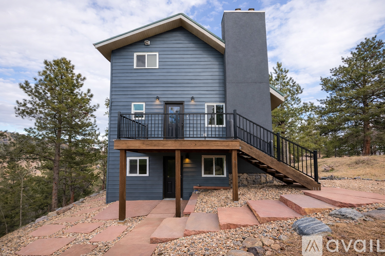 A house with a balcony and a staircase leading to the entrance.