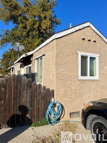 A house numbered 649 with a black dog behind it.