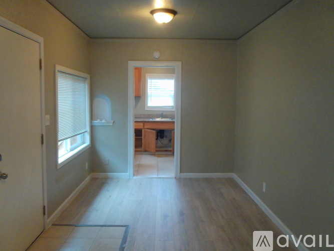 A room with a door, window, and a small table.
