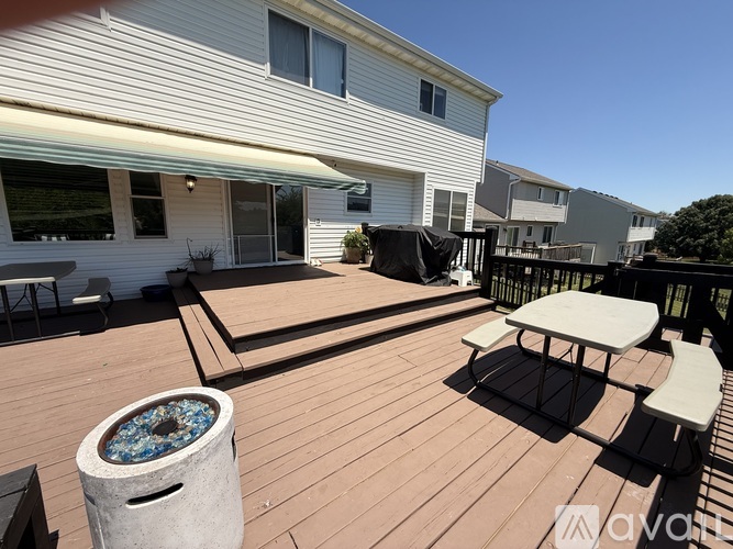 A deck with a table and chairs and a hot tub.