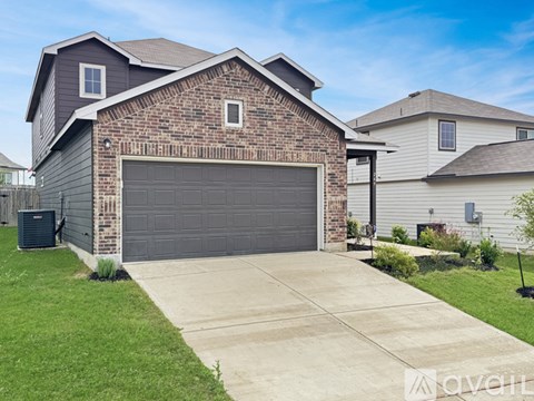 A house with a brick facade and a grey garage door.