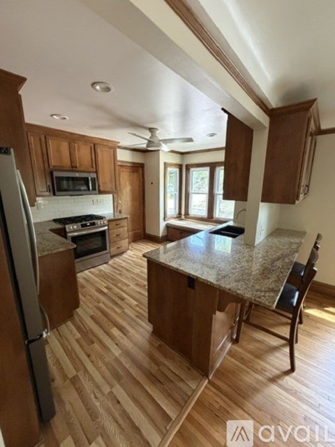 A kitchen with wooden cabinets and a granite countertop.