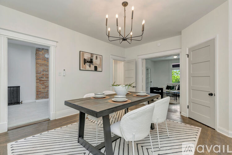 A dining room with a wooden table and white chairs.