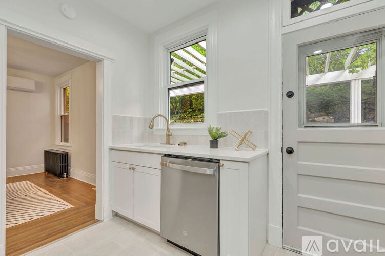 A kitchen with white cabinets and a window.