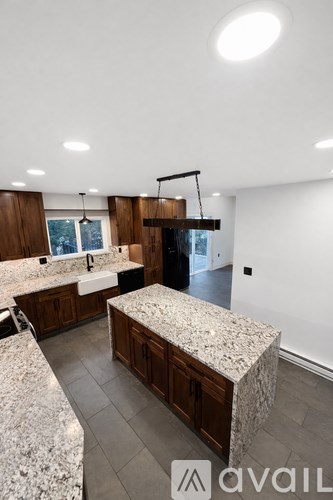 A kitchen with granite countertops and wooden cabinets.