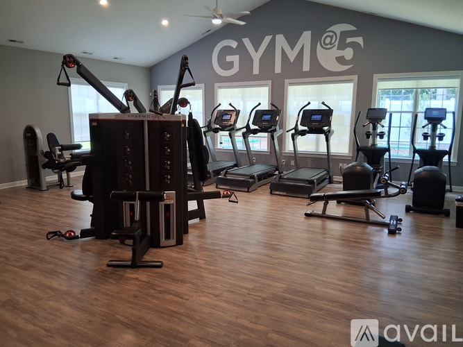 A gym with a variety of equipment including treadmills and weights.