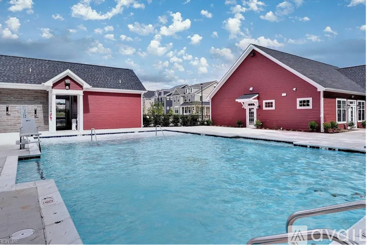 A red house with a pool in front.