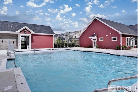 A red house with a pool in front.