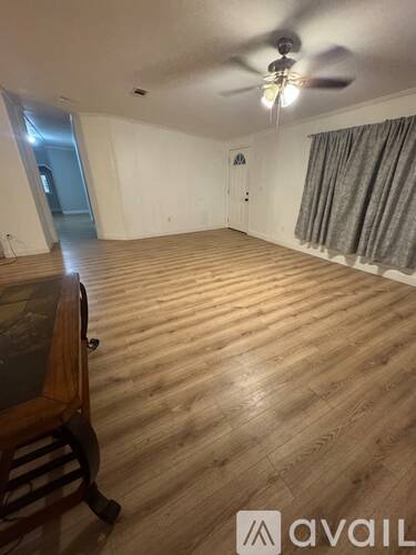 A room with wooden flooring and a ceiling fan.