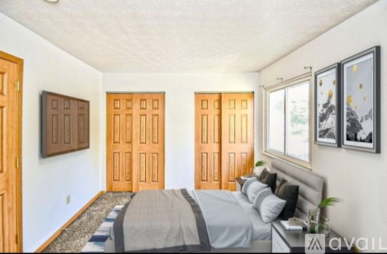 A bedroom with a bed, two doors, and a window.
