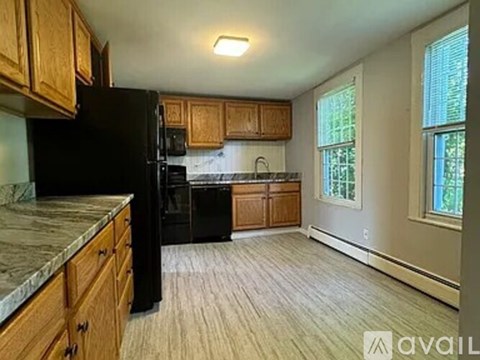 A kitchen with black appliances and wooden cabinets.