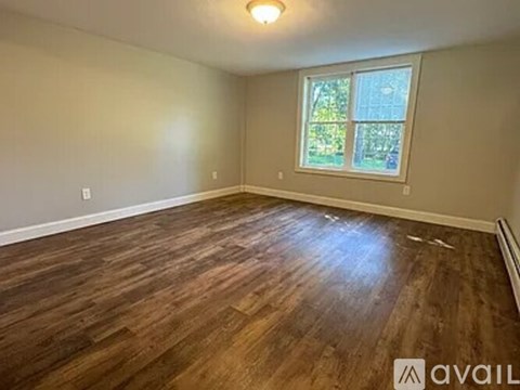 A room with wooden flooring and a window.