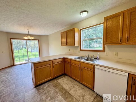 A kitchen with wooden cabinets and a white dishwasher.